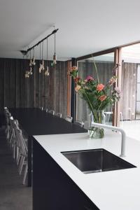una cocina con una encimera con un jarrón de flores. en Maison Albert, en Nieuwpoort