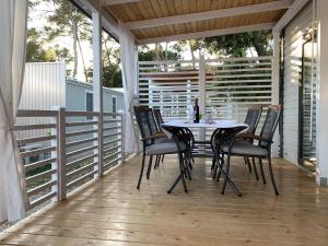 een tafel en stoelen op een veranda met een tafel en stoelen bij Camping Park Soline - Mendula I Mobile Home in Biograd na Moru