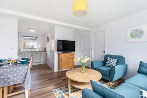 a living room with blue chairs and a table at 40 Norton Park in Dartmouth