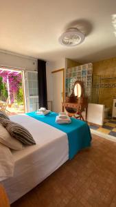 a bedroom with a large bed with a blue blanket at CAN DAMIA 2 in Cala Saona