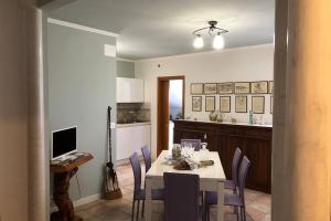 a dining room with a table and chairs and a kitchen at Ampio attico a 5 minuti dal mare in San Benedetto del Tronto
