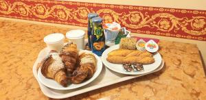 2 assiettes de pain et de viennoiseries sur une table dans l'établissement Hotel Belle Epoque, à Sanremo