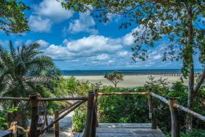 a wooden staircase leading to a beach with a wooden fence at Fundu Lagoon in Pemba +32 photos