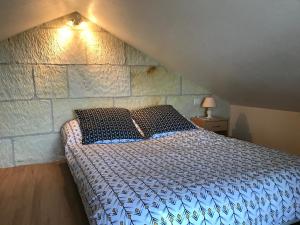 ein Schlafzimmer mit einem Bett und einer Steinwand in der Unterkunft l'Ecrin au coeur des vignes in Saint-Georges-sur-Cher