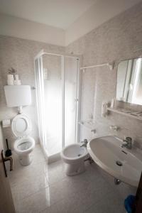 a white bathroom with a toilet and a sink at Casa per Ferie Le Rais in Pozza di Fassa