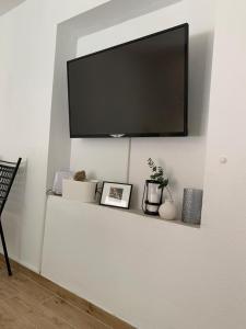 a flat screen tv on a wall with a shelf at House Damić in Korčula