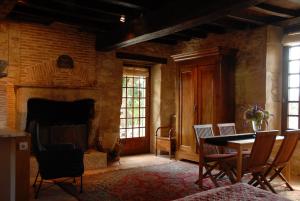 a room with a table and chairs and a fireplace at Chambres d'Hôtes La Bastide des Trémières in Saint-Antoine-de-Breuilh