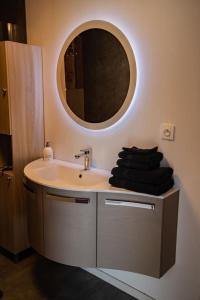 łazienka z umywalką i lustrem na ścianie w obiekcie Repos De La Fontaine w mieście Spa