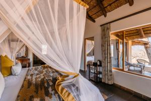 A bed or beds in a room at Thornybush Jackalberry Lodge