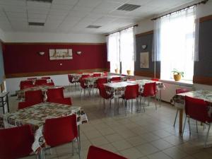 a dining room with tables and red chairs at Penzion Rajf in Krnov