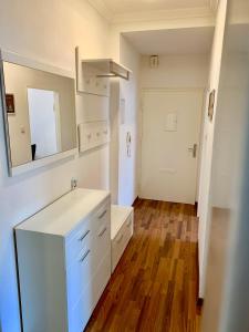 uma cozinha com armários brancos, um espelho e uma porta em Apartment Celin em Hanôver