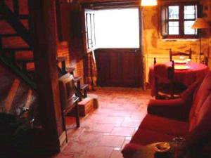 a living room with a couch and a television at La Plazuela in Navalguijo