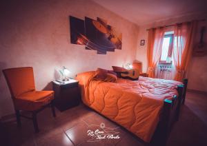 PaganicoLa Casa Sul Fiordo Lago del Turano的一间卧室配有橙色的床和椅子 更多25张照片