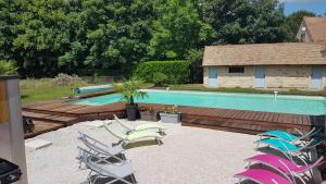 un grupo de sillas sentadas junto a una piscina en Au Petit Pressoir B&B, en Givry