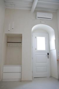 a white door leading to a room with a white toilet at Blanco Rooms Mykonos in Mýkonos City