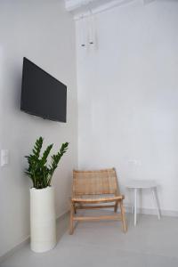 a living room with a tv and a chair at Blanco Rooms Mykonos in Mýkonos City