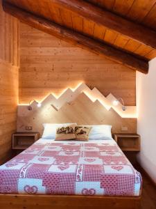 - une chambre avec un lit dans une pièce en bois dans l'établissement Baita Fraina, à Cortina dʼAmpezzo