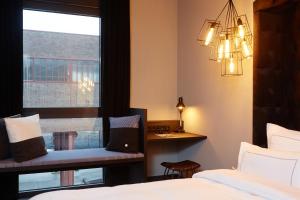 Dormitorio con ventana, cama y escritorio en hotel friends Essen Zeche Zollverein en Essen