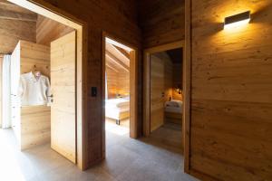 a room with wooden walls and a room with two beds at Chalet Frümsel in Wildhaus