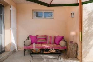 a living room with a pink couch and a table at La Villa ioanes in Port-Saint-Louis-du-Rhône
