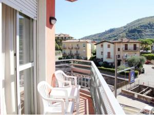 a balcony with white chairs and a view of a city at RTA Doria in Garda