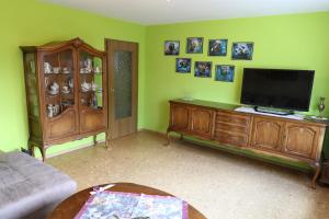 a living room with a flat screen tv and a entertainment center at Haus Lila Welle in Nordhalben +21 photos