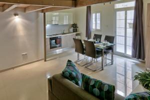 Una sala de estar con un sofá y una mesa con sillas. en Charming Valletta 1 bedroom apartment off Republic Street sleeps 4, en La Valeta