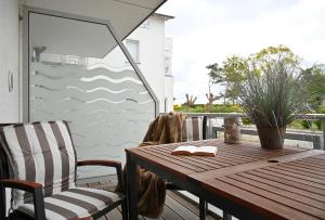 einen Holztisch und zwei Stühle auf einer Terrasse in der Unterkunft Ferienwohnung Badestrand in Juliusruh