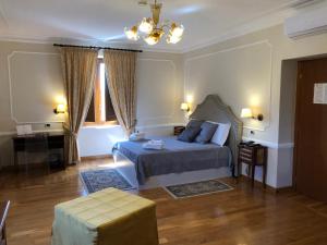 Un dormitorio con una cama y una mesa y una ventana. en Eliceto Resort & SPA, en Buccino 82 fotos más