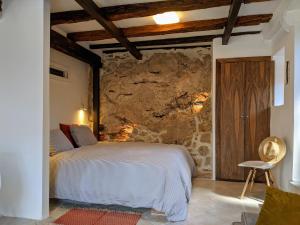 una camera da letto con un letto e un muro di pietra di Best view! Rooftop with Garden - Old Town Nr404 a Kotor (Cattaro)