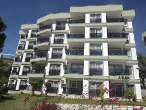 een groot wit appartementencomplex met een bord erop bij Opus Apart Hotel in Kuşadası