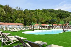 une piscine avec des chaises longues sur une pelouse dans l'établissement Eco Complex Izvori, à Varna
