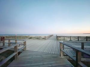 un paseo marítimo que conduce a la playa con 2 bancos en Casasuul Alvor, en Alvor