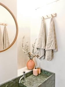 Un baño con lavabo, espejo y toallas. en Casasuul Alvor, en Alvor