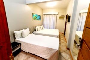 une chambre d'hôtel avec deux lits et une télévision dans l'établissement Brasil Express, à Balneário Camboriú