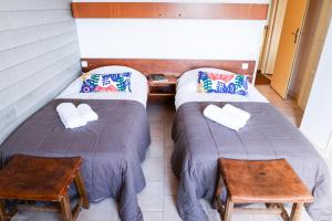 2 camas individuales en una habitación con 2 mesas en Residence Les Cimes, en Font-Romeu