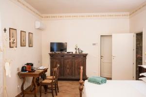 Schlafzimmer mit einem Schreibtisch, einem Bett und einem Tisch in der Unterkunft Podere Lornanino in Monteriggioni