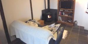 a living room with a couch and a fireplace at The Buttery at Woodend in Broughton in Furness