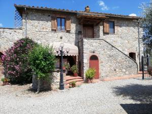 a large stone house with a red door at Podere Lornanino in Monteriggioni