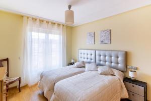 een slaapkamer met een groot bed en een raam bij Housingleón - Parque de las Artes con Garaje in León