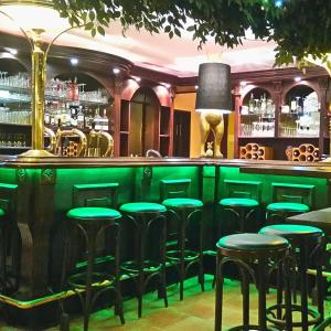 a bar with green stools in a restaurant at Hotel am Hasengarten in Bad Bederkesa