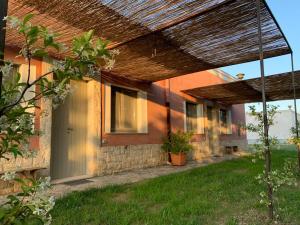 a house with a porch with a wooden roof at Masseria Montedoro in Ginosa Marina