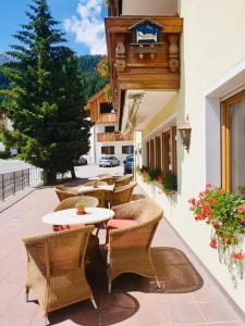 a patio with tables and chairs on a building at Apartments Bracun in Corvara in Badia