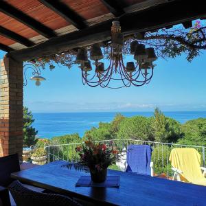 una mesa azul con vistas al océano en casa panoramica bouganville en SantʼAndrea