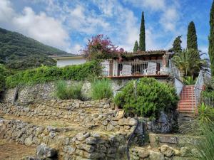 una casa en una colina con una pared de piedra en casa panoramica bouganville, en SantʼAndrea