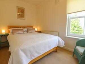 a bedroom with a large white bed and a window at Cherry Lodge in Newark upon Trent