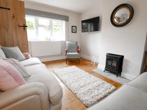 a living room with a white couch and a fireplace at Bennett's Cottage in Oakham