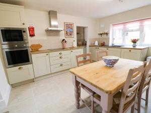 cocina con mesa de madera y comedor en Bennett's Cottage en Oakham