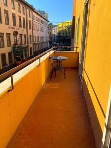 balkon ze stołem i krzesłami w żółtym budynku w obiekcie De Gasperi House w mieście Napoli