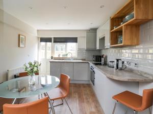 a kitchen with a glass table and some chairs at Troopers Cottage in Frome
